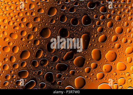 Gros plan d'une goutte d'eau sur un fond dégradé orange et brun, couvert de gouttes d'eau -la condensation. Banque D'Images