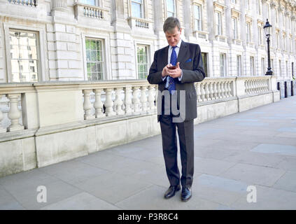 Dominic Grieve MP (Conservateur : Beaconsfield) ancien Attourney Général sur son téléphone mobile dans Whitehall Banque D'Images