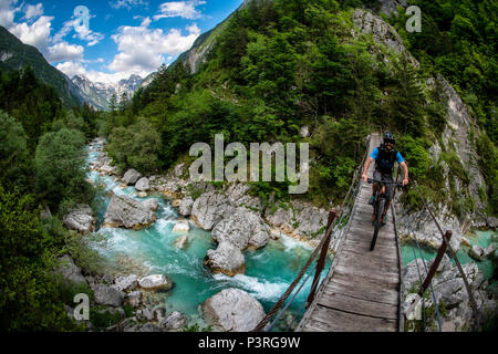 Une des promenades en vélo de montagne à travers un pont de bois sur la rivière Soca en Slovénie, l'Europe. Banque D'Images