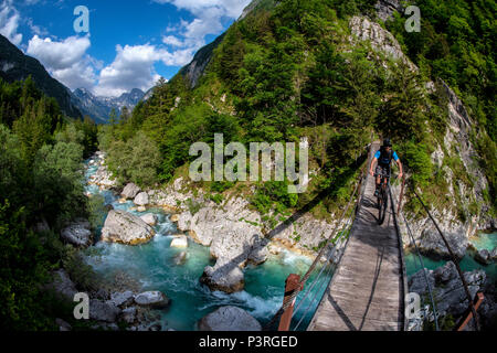 Une des promenades en vélo de montagne à travers un pont de bois sur la rivière Soca en Slovénie, l'Europe. Banque D'Images