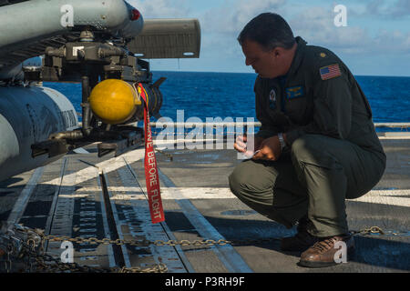 160714-N-OL837-051 OCÉAN PACIFIQUE (14 juillet 2016) - Le Lieutenant Cmdr. Rob Neff de Malte, New York, officier responsable de l'Escadron d'hélicoptères grève maritime (HSM), 75, 2, du Détachement effectue des vérifications avant vol d'un missile AGM-114 Hellfire sur le poste de pilotage de l'croiseur lance-missiles USS Princeton (CG 59) avant un exercice de tir réel naufrage, ou SINKEX, lors de Rim of the Pacific 2016. Vingt-six nations, plus de 40 navires et sous-marins, plus de 200 avions, et 25 000 hommes participent à l'EXERCICE RIMPAC du 30 juin au 4 août, dans et autour des îles Hawaï et la Californie du Sud. Le monde Banque D'Images