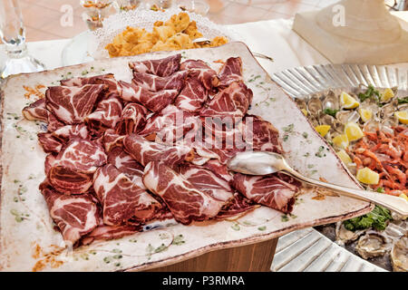 Saveurs italiennes : bacon tranché dans un plat de service placé sur une table élégante - selective focus Banque D'Images