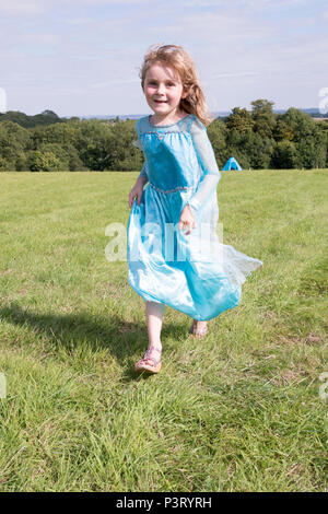 Chepstow, Pays de Galles - 19 Août 14 : Jeune fille courir dans une belle robe de princesse célèbre arrivant sur des vacances d'été, 14 août 2016 à la collecte verte F Banque D'Images