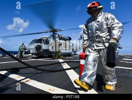 160729-N-KR702-210 OCÉAN PACIFIQUE (Juin 29, 2016) - Dommage Controlman 3 classe Erik Michel, affecté à la classe Arleigh Burke destroyer lance-missiles USS Shoup (DDG 86), promenades dans une zone de sécurité sur le pont après la fixation d'un ravitaillement en mer MH-60R Hawk attaché à l'agicians «' de l'Escadron d'hélicoptères grève maritime (HSM) 35 tout en menant des opérations de vol, au cours de l'2016. Vingt-six nations, plus de 40 navires et sous-marins, plus de 200 avions et 25 000 personnes participent à l'EXERCICE RIMPAC du 30 juin au 4 août, dans et autour des îles Hawaï un Banque D'Images