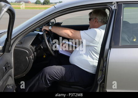 Les agents de police belge vérifier la vitesse d'un véhicule passant un radar de vitesse sur la piste de la Base Aérienne de Chièvres, mardi 26 juillet, 2016. La Police militaire de Chièvres a conclu un accord avec la Police fédérale belge du Hainaut d'utiliser la piste d'une fois par an pour l'étalonnage de l'indicateur des deux militaires américains et les véhicules de la police belge. Les véhicules passent le radar à des vitesses stabilisées avec des incréments de 10 km/h, et le radar fournit la vitesse réelle. (U.S. Photo de l'armée par Visual Spécialiste de l'information Henri Cambier) Banque D'Images