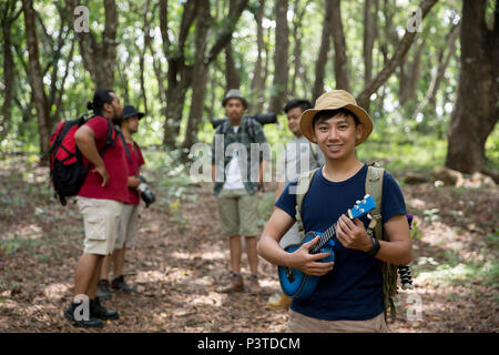 Homme avec ukulele randonnées à la forêt Banque D'Images