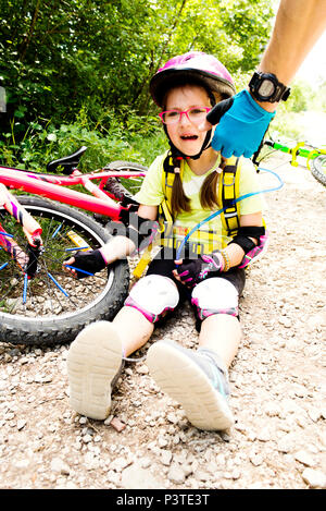 Petite fille pleurer après tomber de son vélo Banque D'Images