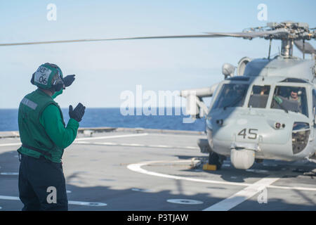 160726-N-MW990-007 OCÉAN PACIFIQUE (Juillet 26, 2016) l'Aviation Machiniste 4400 2e classe Kyle Angleterre rattaché à l'Escadron d'hélicoptères de combat de la mer littoral 23 déployés avec la lutte contre le USS Coronado (LCS 4) communique avec les pilotes utilisant des signaux à main avant le décollage lors de Rim of the Pacific 2016. Vingt-six nations, plus de 40 navires et sous-marins, plus de 200 avions, et 25 000 hommes participent à l'EXERCICE RIMPAC du 30 juin au 4 août, dans et autour des îles Hawaï et la Californie du Sud. Le plus grand exercice maritime international RIMPAC, fournit une formation unique oppo Banque D'Images