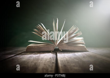 Vieux livre ou Sainte Bible ouverte sur une table avec spot light Banque D'Images