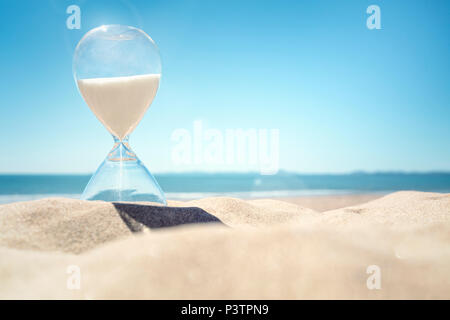 Temps de sablier sur une plage dans le sable avec ciel bleu et copy space Banque D'Images