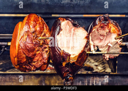 Jarret rôti traditionnel jambon cuisson sur charbon de spit torréfacteur. La viande fraîche et juteuse cutted. Prague, République Tchèque Banque D'Images