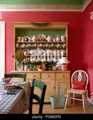 Collection de bols de poterie et les plaques sur grand vaisselier pin rose profond en salle à manger avec chaise Windsor Banque D'Images