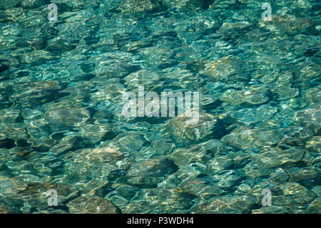 La texture de l'eau de mer couleur émeraude avec des pierres brille à travers l'eau de mer Banque D'Images