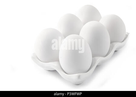 6 grands oeufs blancs sur un plat de céramique blanche Banque D'Images
