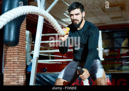 Un mouvement sportif brutal des cordes en salle de sport Banque D'Images