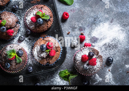 Orange chocolat muffins ou cupcakes décorés avec les baies fraîches. Maison saine à la cuisson. Vue de dessus avec l'exemplaire de l'espace. Banque D'Images