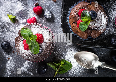 Orange chocolat muffins ou cupcakes décorés avec les baies fraîches. Maison saine à la cuisson. Vue d'en haut. Banque D'Images