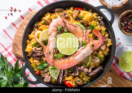 Paella aux fruits de mer. Le plat traditionnel espagnol, une cuisine européenne. Vue de dessus sur la table en bois blanc. Banque D'Images