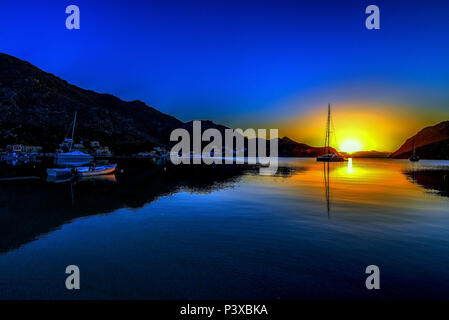 Sunrise de bord de l'eau dans la baie de Pedi, Symi, Grèce Banque D'Images