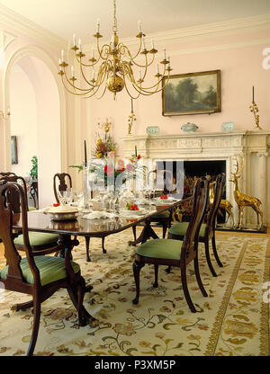 Plus de lustre acajou antique table à manger et chaises en grande salle à manger avec un tapis à motifs Banque D'Images