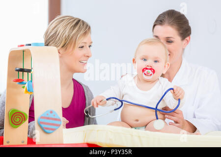 Bébé en santé et mignon fille jouant avec le stéthoscope pendant l'examen Banque D'Images