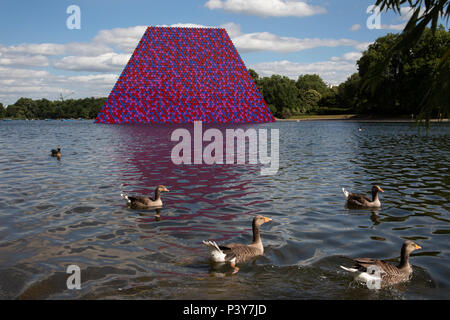 L'installation d'art par l'artiste Christo, mastaba, installé sur le lac Serpentine, à Hyde Park le 18 juin 2018 à Londres, Royaume-Uni. La sculpture se compose de 7 506 tonneaux empilés, peint dans les tons de rouge, blanc, bleu et mauve. Le morceau fait partie d'une exposition de Christo et de son épouse décédée, Jeanne-Claudes, intitulé Christo et Jeanne-Claude : barils et le mastaba 19582018 qui se tiendra à la Serpentine Gallery. Banque D'Images