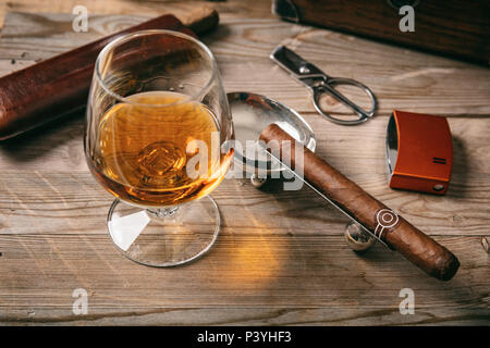 Cigare cubain et un verre de cognac brandy sur fond de bois, gros plan Vue de dessus Banque D'Images