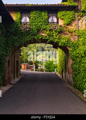 Biella, Italie, 10 juin 2018 - maison ancienne, les murs couverts de lierre et d'arche reliant la deuxième partie de la chambre avec road ci-dessous, Italie Banque D'Images