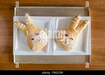 Deux gâteaux doux lapin de Pâques sur les plaques et bac dans une boulangerie Banque D'Images