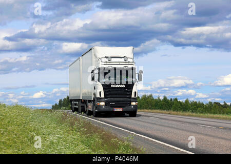 Scania R440 blanc camion et remorque pleine d'Melkoset Oy transporte des marchandises sous ciel magnifique sur la route d'été à Jamsa, Finlande - le 14 juin 2018. Banque D'Images