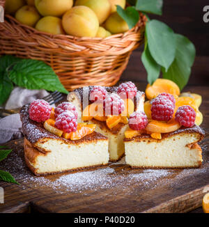 Morceaux de Tarte au fromage cottage avec des fraises et d'abricots sur une planche de bois brun, Close up Banque D'Images