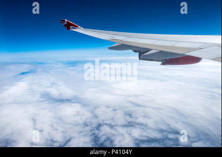 Vue depuis la fenêtre de l'avion de l'aile et le moteur avec cloudscape Banque D'Images