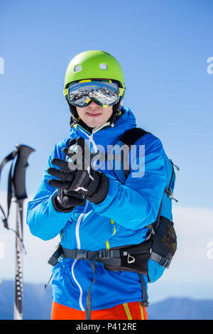 Photo de l'homme d'en casque et lunettes avec bâtons de ski sur journée d'hiver Banque D'Images