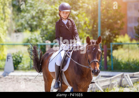 Teenage girl riding bay horse effectuant le test de dressage compétition équestre sur Banque D'Images