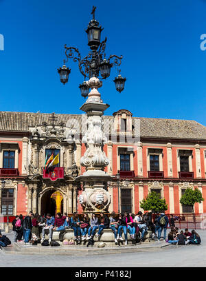 Les touristes assis autour de la Plaza Virgen de los Reyes fontaine à l'extérieur du palais de l'archevêque, Séville, Andalousie, espagne. Banque D'Images