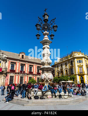 Les touristes assis autour de la Plaza Virgen de los Reyes fontaine à l'extérieur du palais de l'archevêque, Séville, Andalousie, espagne. Banque D'Images