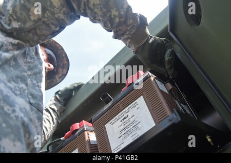 COATEPEQUE, Guatemala - La Garde nationale de l'Arkansas Le Sgt. James Crowe, 875th avant Support Société mécanicien véhicule à roues, resserre un collier sur une batterie dans un réservoir d'alimentation en eau 1 Juin, 2016, au cours de l'effort AU-DELÀ DE L'HORIZON 2016 AU GUATEMALA. Le collier de fixation de la batterie en place afin que les connexions ne sont pas sorties pendant que l'eau du réservoir d'alimentation est transporté. (U.S. Photo de l'Armée de l'air par la Haute Airman Dillon Davis/libérés) Banque D'Images