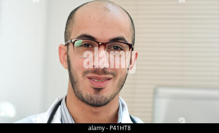 Médecin arabe masculine positive de parler à l'appareil photo Banque D'Images