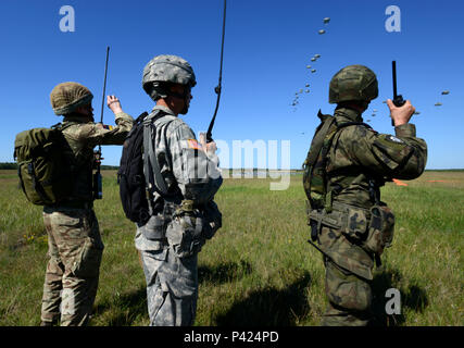 Soldats multinationales observer que l'équipement lourd est diminué au cours de l'exercice au cours de la zone de dépôt de Torun Réponse rapide. L'exercice est l'un des premiers événements de formation en intervention de crise militaire pour les forces aéroportées dans le monde. L'exercice est conçu pour améliorer l'état de préparation de la base de combat de la Force de réaction des Etats-Unis dans le monde - actuellement la 82nd Airborne Division, 1ère Brigade Combat Team-d'effectuer à réponse rapide, de l'entrée par effraction et de suivi sur les opérations aux côtés des forces à haut niveau de préparation des forces alliées en Europe. Réponse rapide 16 comprend plus de 5 000 soldats et aviateurs à partir de Banque D'Images