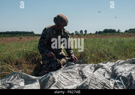 Le colonel Colin Tuley, commandant, 1e Brigade Combat Team, 82nd Airborne Division récupère son parachute après un saut dans Torun, Pologne, au cours de l'effort, le 8 juin 2016 Anakonda. En 2016, un exercice Anakonda-polonaise, a conduit un exercice multinational de juin 7-17, auprès d'environ 31 000 participants de plus de 20 nations et est un événement de formation de l'armée américaine pour l'Europe. L'Europe de l'armée américaine a plus de 15 ans de coopération militaire avec la Pologne. Banque D'Images