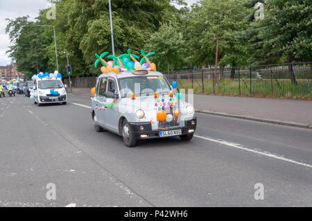 Glasgow, Ecosse, Royaume-Uni. 20 Juin, 2018. La 73e sortie de taxi de Glasgow est un événement annuel où plus de 100 chauffeurs de taxi de la ville s'habillent en costumes de fantaisie, décorer leurs taxis et prendre plus de 300 enfants ayant des besoins spéciaux sur une journée à la station balnéaire de Troon. En photo un taxi sur la route décoré avec des ballons colorés. Credit : Skully/Alamy Live News Banque D'Images