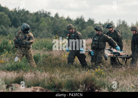 Médecins polonais transporter un soldat blessé sur une litière dans le cadre de la simulation d'un exercice d'évacuation de blessés durant l'exercice 2016 Anakonda (UN16) à la base aérienne de Miroslawiec, Pologne, 11 juin 2016. Une16 une multinationale dirigée par la Pologne, l'événement de formation, allant du 7 au 17 juin, auprès d'environ 31 000 participants de plus de 20 nations et est un événement de formation de l'armée américaine pour l'Europe. Banque D'Images