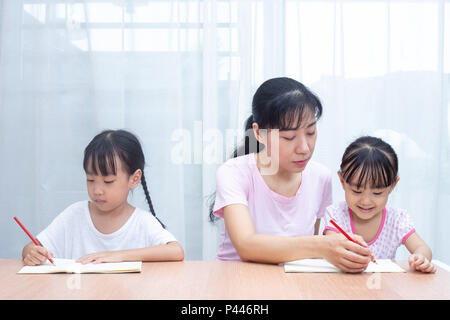 Mère Chinoise Asiatique filles d'enseignement à faire leurs devoirs à la maison Banque D'Images