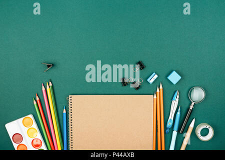 Bureau de l'élève avec l'arrêt sur fond vert. Préparation à l'école. Banque D'Images