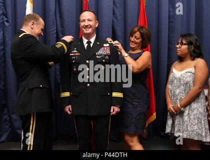 Le lieutenant général Stephen Lyons (à gauche), sous-, U.S. Transportation Command, Jennifer (deuxième à droite), et de Madison (à droite), 'pin-sur' le nouveau grade de major général à nouveau Commandant général Kurt J. Ryan. Banque D'Images