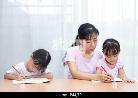 Mère Chinoise Asiatique filles d'enseignement à faire leurs devoirs à la maison Banque D'Images