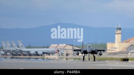 Un U.S. Air Force F-15E Strike Eagle tous les temps, très manœuvrable, chasse double rôle attribué au 494e Escadron de chasse de la Royal Air Force de Lakenheath, en Angleterre, les taxis Eielson Air Force Base, Alaska, ligne de vol passé une rangée de garé Alaska Air National Guard KC-135 Stratotanker ravitaillement en vol affecté à la 168e Escadron de ravitaillement en vol, le 6 juin 2016, au cours de l'exercice Red Flag Alaska (RF-A) 16-2. RF-A est une série de Pacific Air Forces commandant réalisé des exercices pour les États-Unis et les forces du pays partenaire comme la liberté et leur aile, unités internationales à forte Banque D'Images