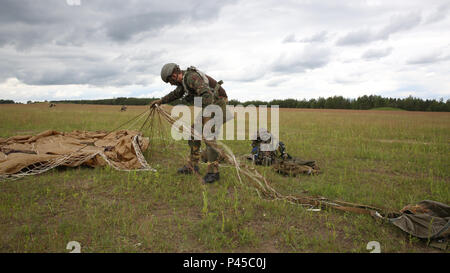 Un soldat néerlandais de la Compagnie Alpha, 11e Bataillon d'infanterie, 11ème brigade aéromobile sécurise son parachute lorsqu'on réalise une opération aéroportée au cours de réponse rapide 16 entraînement physique à la zone d'entraînement, un Hohenfels partie du centre de formation interarmées multinationale, à Grafenwoehr, Allemagne, Jun. 15, 2016. La réaction rapide de l'exercice est l'un des premiers événements de formation en intervention de crise militaire pour les forces aéroportées dans le monde. L'exercice est conçu pour améliorer l'état de préparation de la base de combat de la Force de réaction des Etats-Unis dans le monde - en ce moment la 82nd Airborne Division, 1ère Brigade Banque D'Images