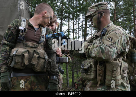 Un soldat américain, à droite, de l'équipe Timberwolf, Centre de préparation interarmées multinationale (Operations Group) synchronise le Système intégré de prises à parties multiples au laser d'un soldat néerlandais de la Compagnie Alpha, 11e Bataillon d'infanterie, 11ème brigade aéromobile tout en menant des opérations aéroportées au cours de réponse rapide 16 entraînement physique à la zone d'entraînement, un Hohenfels partie du centre de formation interarmées multinationale, à Grafenwoehr, Allemagne, Jun. 15, 2016. La réaction rapide de l'exercice est l'un des premiers événements de formation en intervention de crise militaire pour les forces aéroportées dans le monde. L'exercice est Banque D'Images