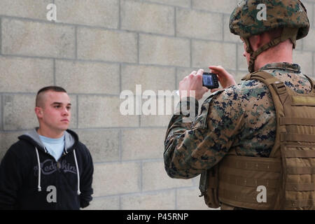 Le sergent du Corps des Marines des États-Unis. Taylor R. Lefevre, avec des Groupe Force-Crisis Response-Africa air-sol marin capture une photo d'un civil simulé pour les identifier lors d'une opération d'évacuation de non-combattants exercice organisé par l'armée française pour le combat urbain centre de formation des instructeurs à bord de Sissonne Camp, France, le 21 juin 2016. SPMAGTF-CR-AF Marines formés aux côtés d'une compagnie de soldats de l'armée française, l'intégration de leurs compétences et ressources pour créer un plan de bataille efficace, semblable à ce qu'ils peuvent rencontrer dans le cas d'une crise future. (U.S. Marine Corps photo par le Sgt. Kassie L. Banque D'Images